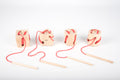 Wooden lacing shape blocks with red laces and wooden dowel lacing tools