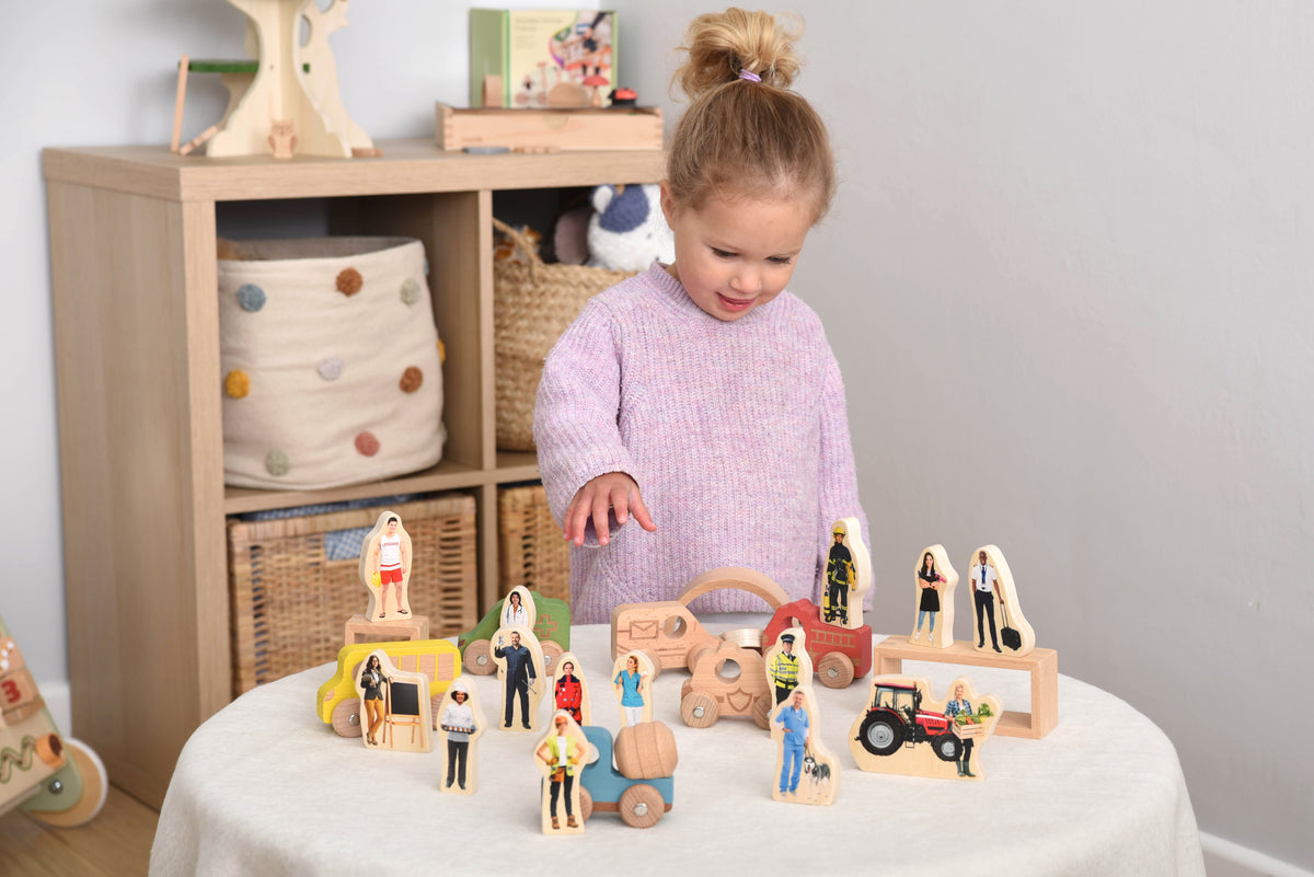 Wooden people figure blocks set with standing characters, vehicles, and wheeled cart