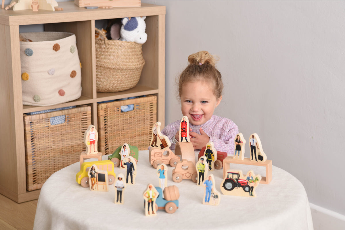 Wooden people figurines with block vehicles, carts, and rounded carriage pieces