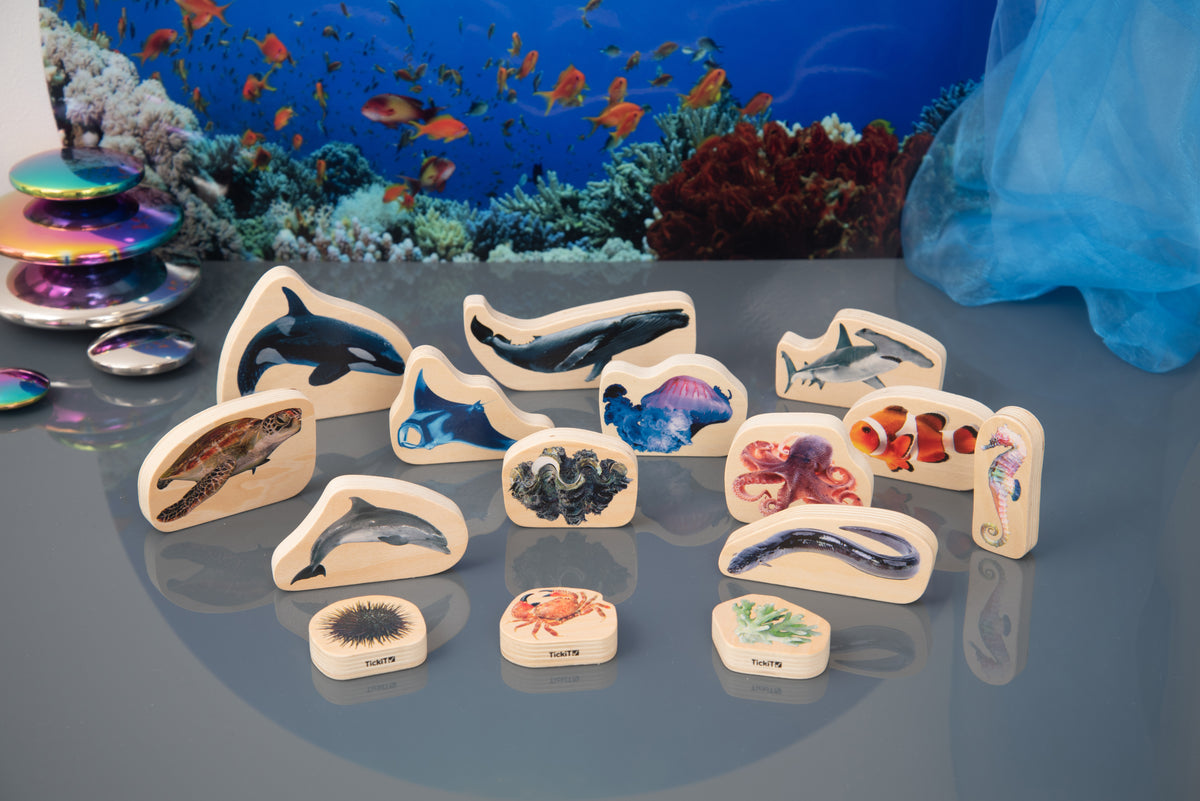 Wooden sea animal blocks on a blue ocean tray with dolphins, stingray and octopus