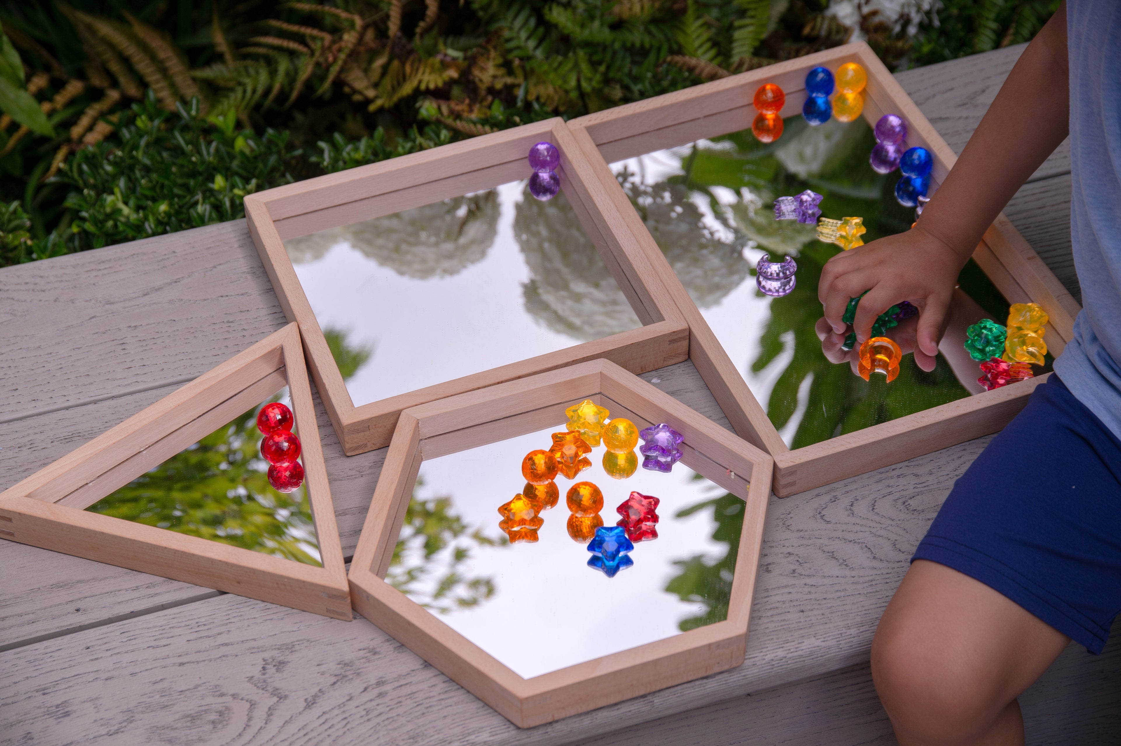 Wooden mirror tray set of 4 with light wood frames and clear mirrors, filled with colorful beads