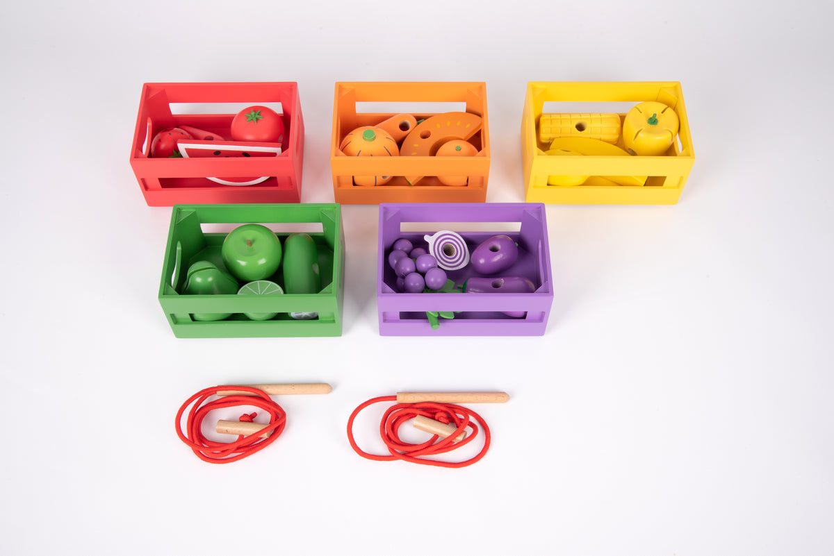 Rainbow wooden sorting crates filled with toy fruit, with red lacing cords