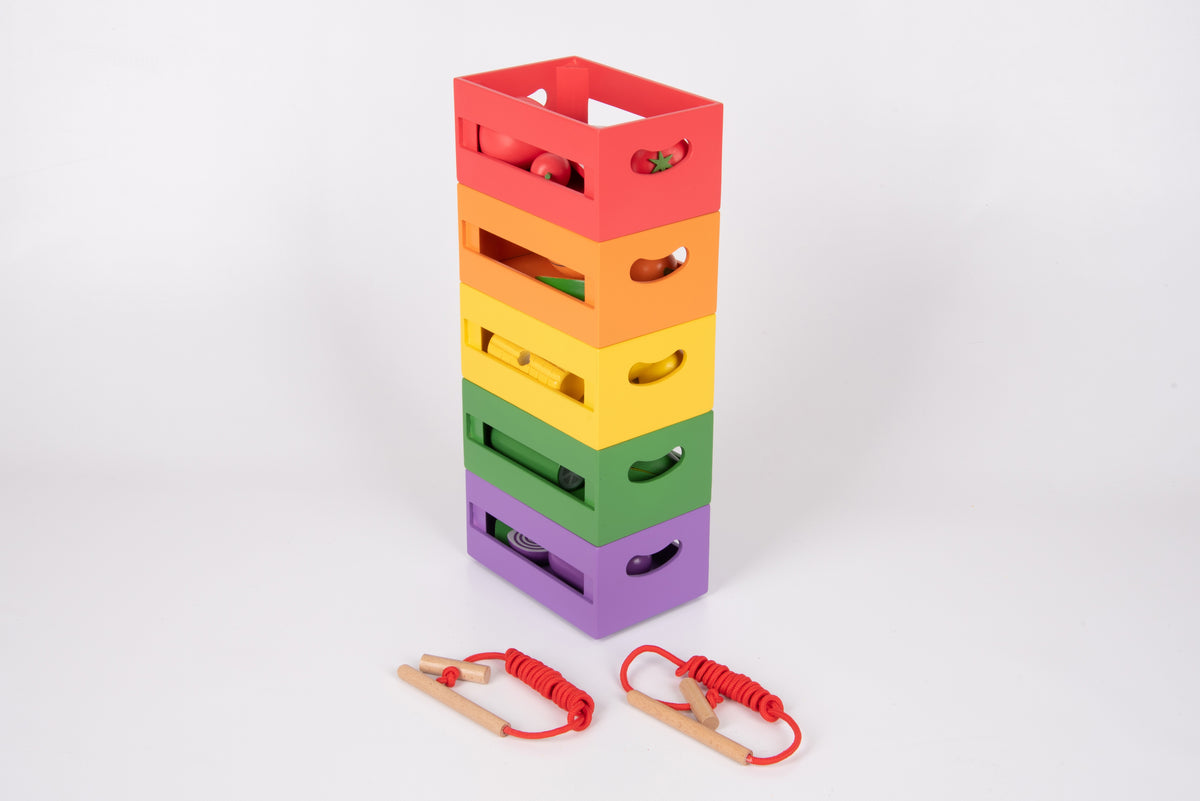 Stacked rainbow wooden sorting crates with toy fruit pieces and red lacing cords