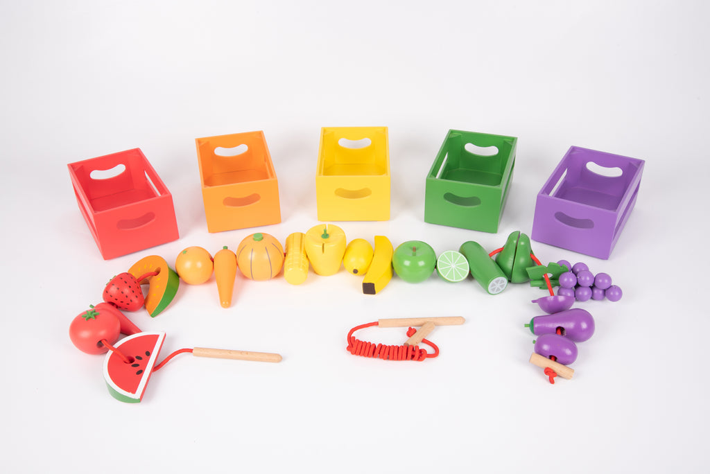 Colorful wooden sorting crates with toy fruit and vegetables plus red-handled tools