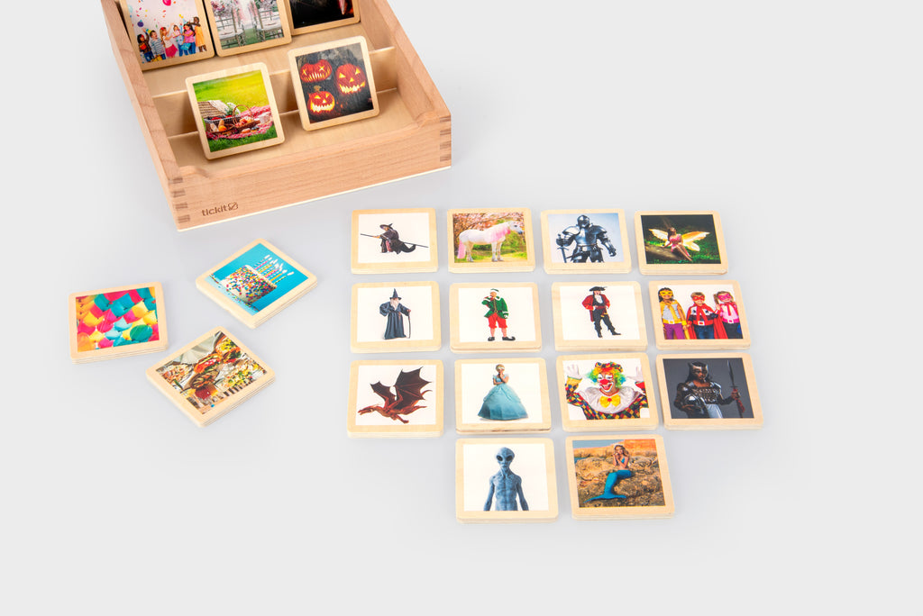 Wooden story tile box with loose photo tiles showing people, costumes, and outdoor scenes