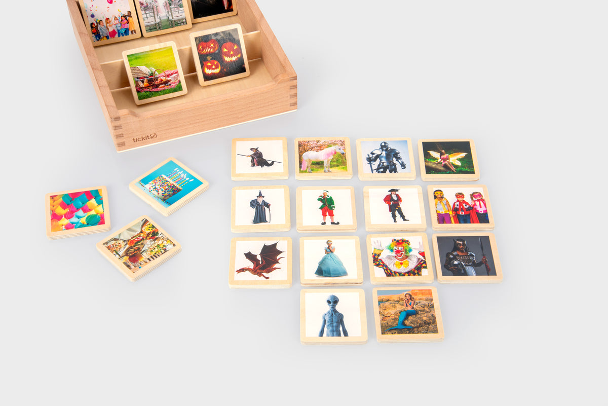 Wooden story tile box with loose photo tiles showing people, costumes, and outdoor scenes