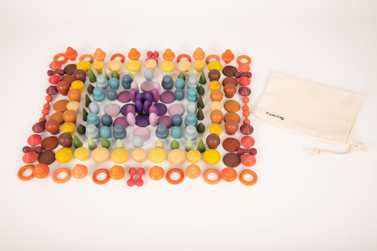 Colorful wooden peg grid pattern with scattered pieces and a cream drawstring pouch.