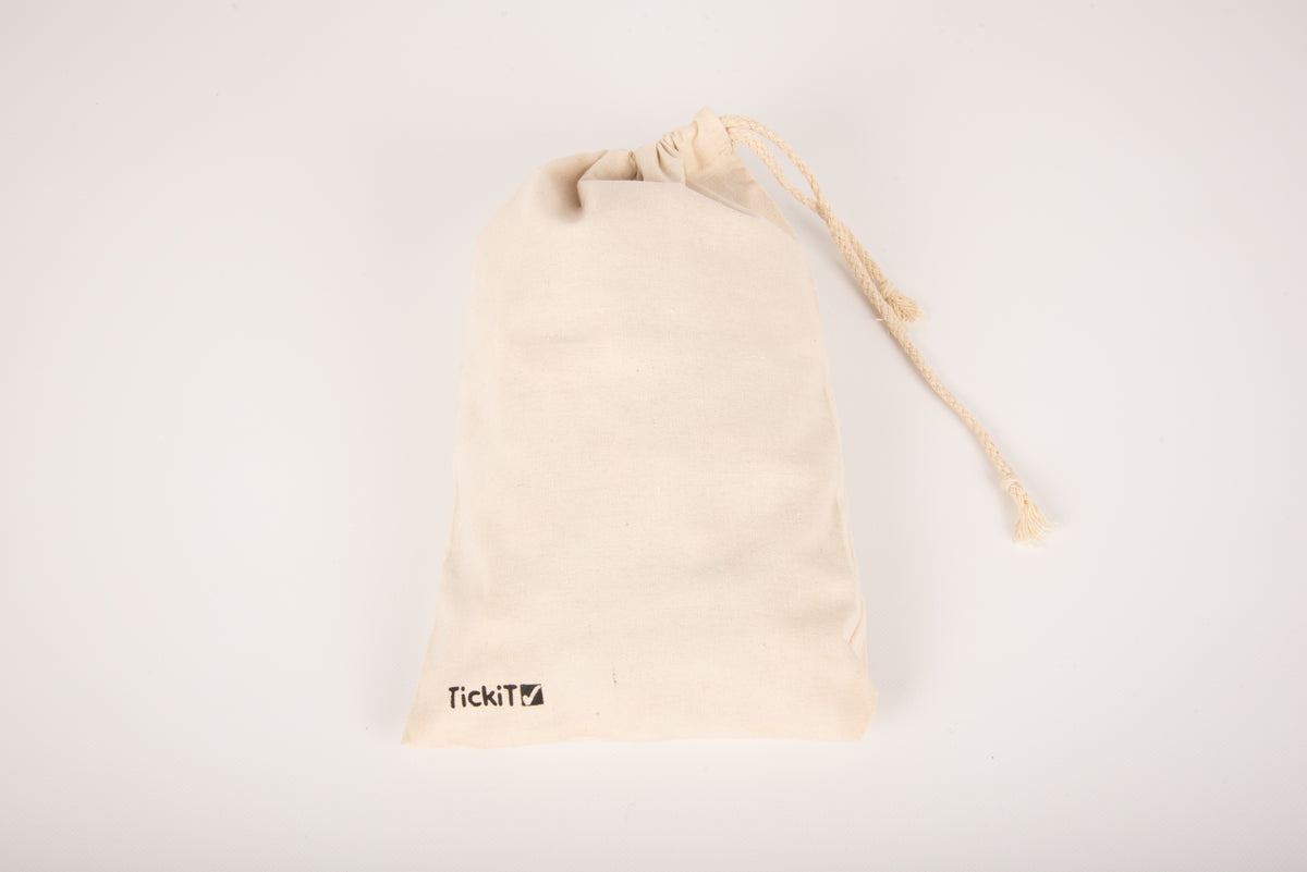 Cream drawstring pouch with tassel and TikiTi logo on the lower front.