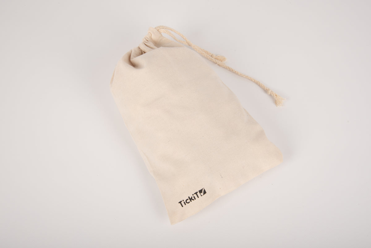 Cream cotton drawstring pouch with small tassel and TikiTi label at bottom.