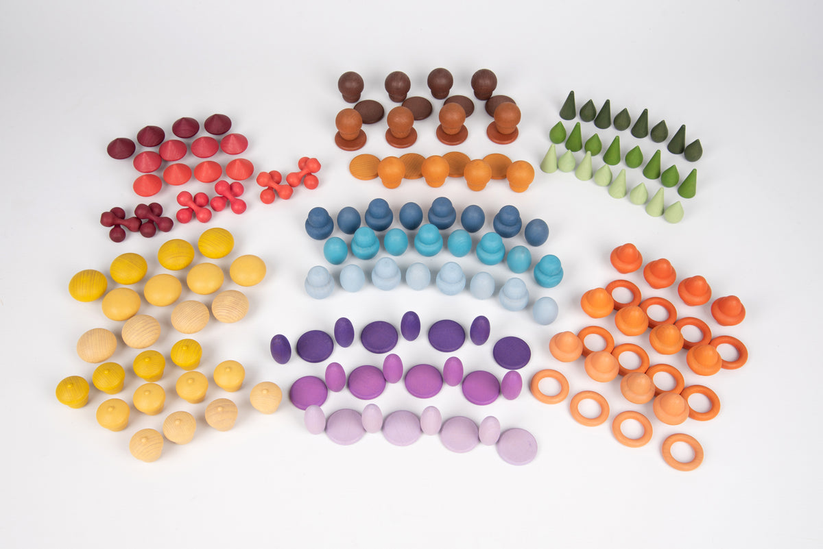 Wooden peg pieces arranged by color: red, yellow, brown, green, blue, and orange rings.