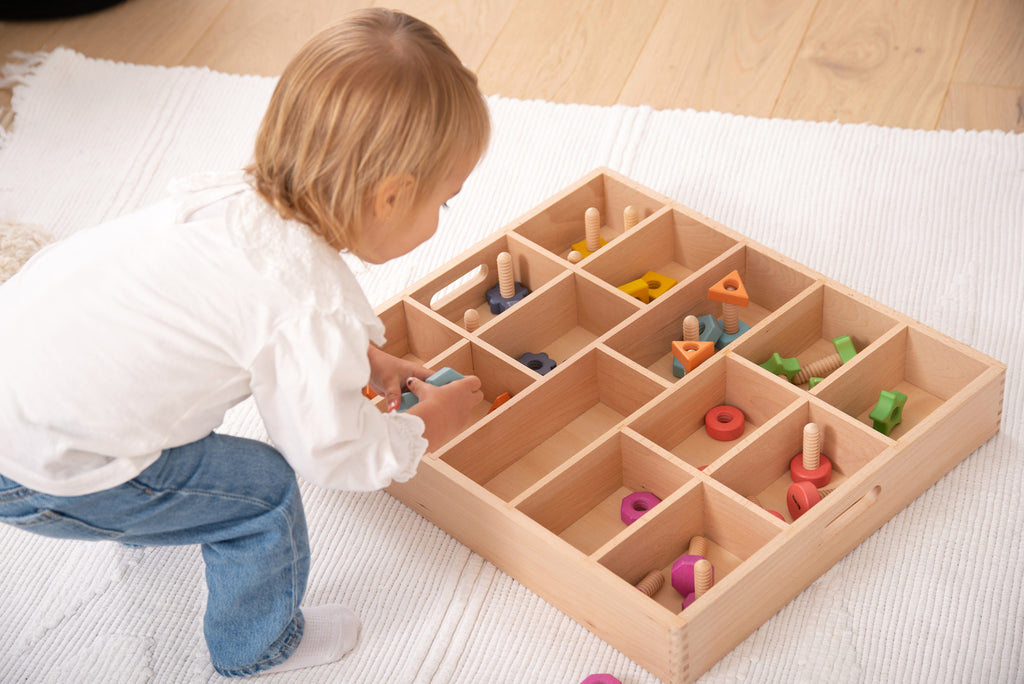 Wooden sorting tray with 14 compartments of colorful wooden pieces, shown from side