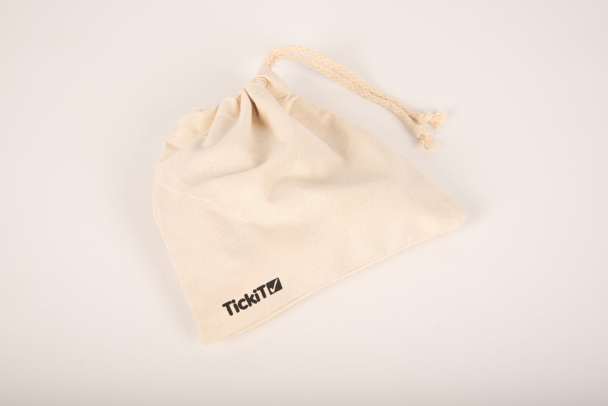 Cream drawstring pouch with TickiT logo and handle cord, tilted