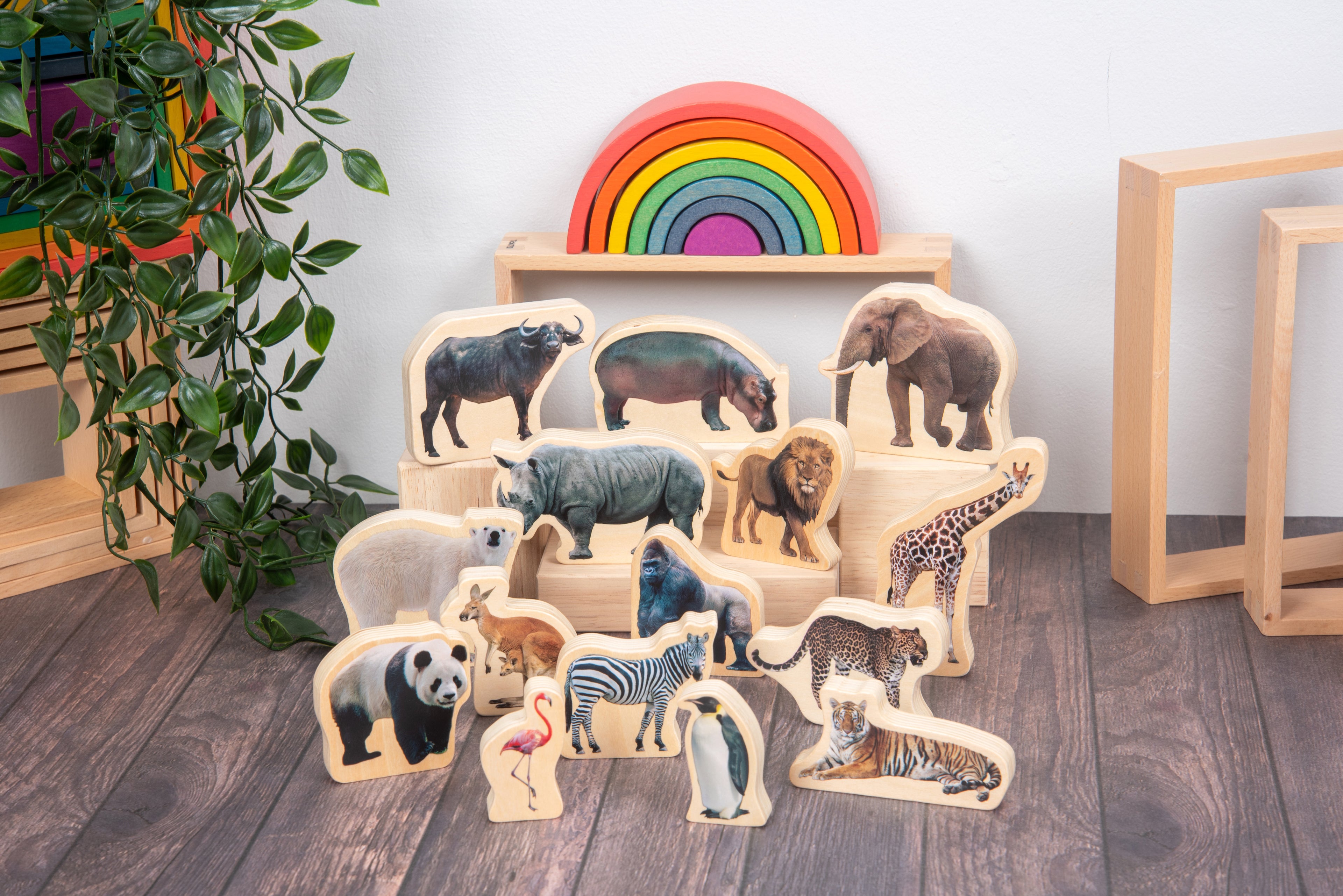 Stacked wooden wild animal blocks showing safari animals near a rainbow