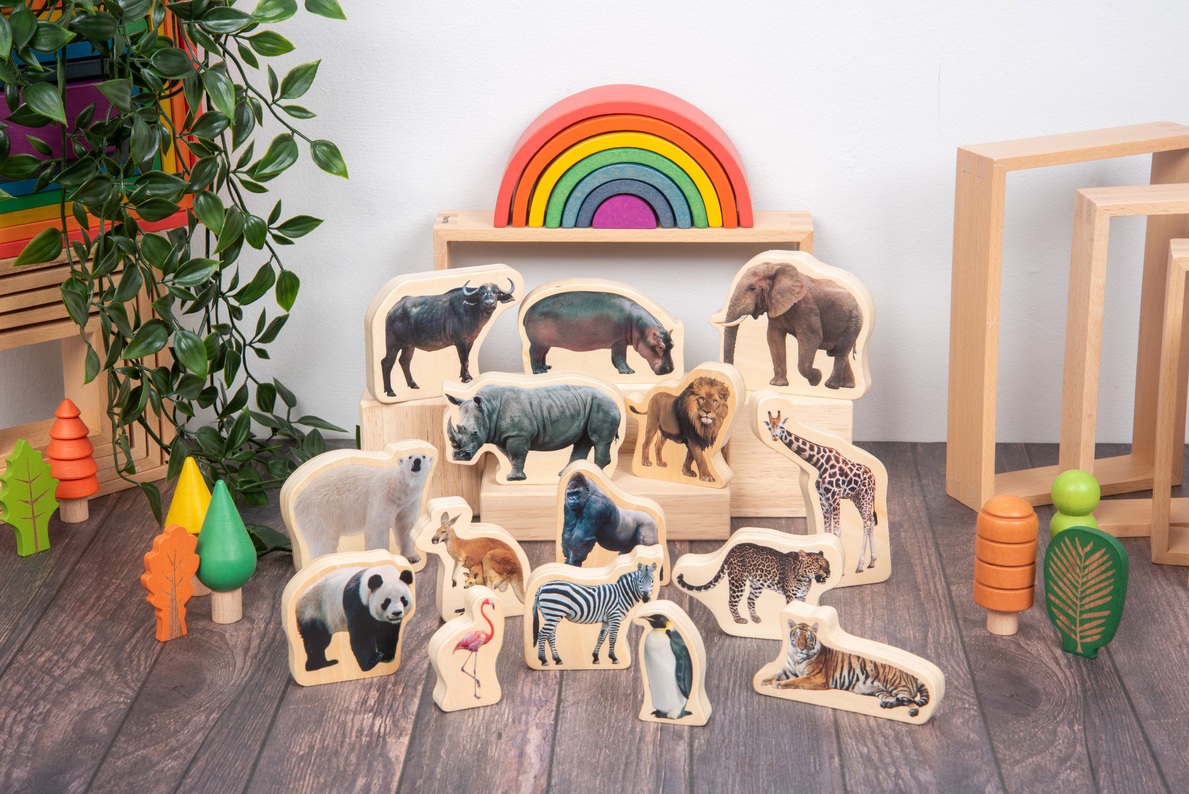 Wooden wild animal blocks with mounted animals arranged near a rainbow play arch