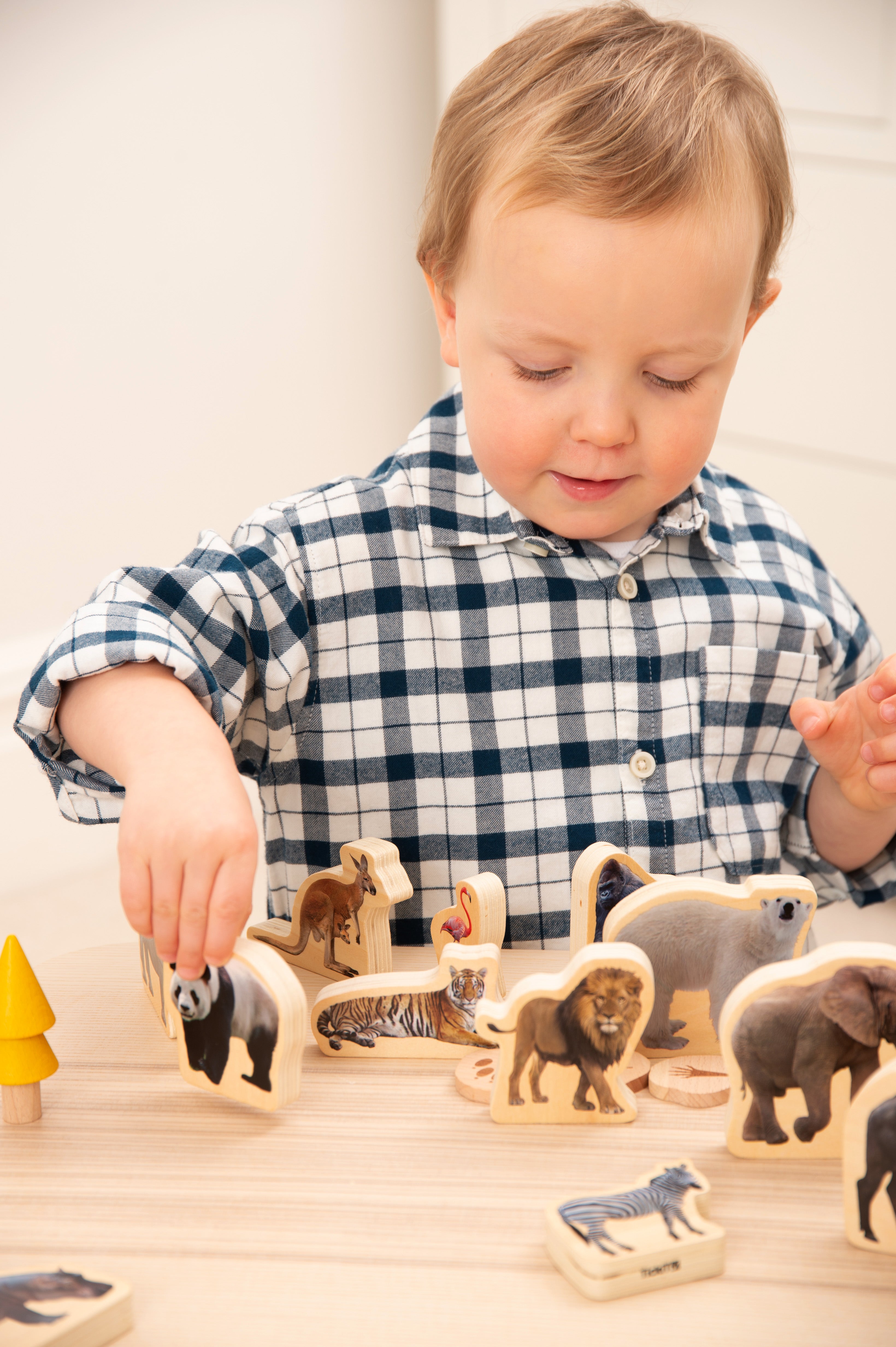 Child playing with wooden wild animal blocks and animal-shaped pieces