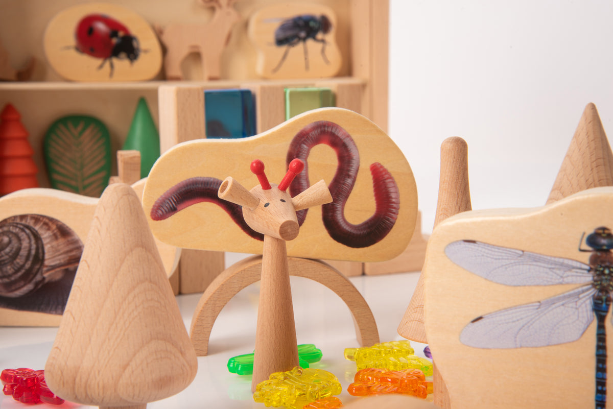 Wooden animal-spinning figure on a base, with ladybug and dragonfly tiles in the background