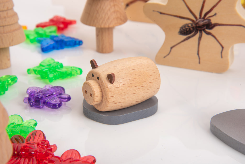 Wooden log roller toy with rounded wooden end and dark gray base, surrounded by colorful parts