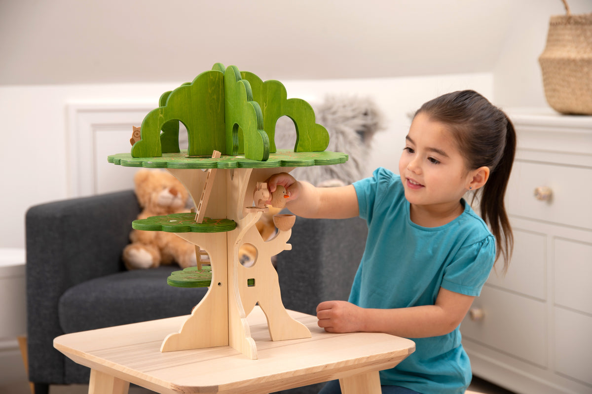 Wooden treehouse playset with green leaf canopy, ladder, and animal figures