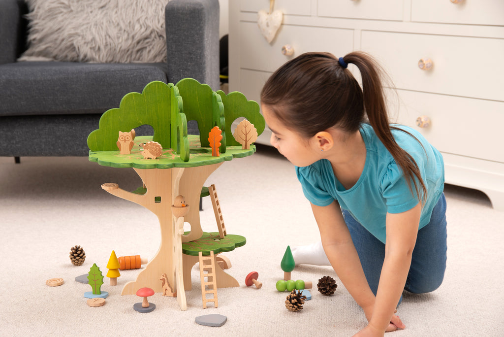 Wooden treehouse playset with green canopy and ladder, with toy pieces