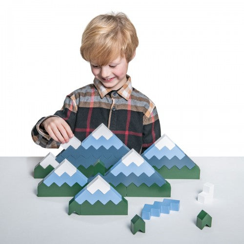 Mountain-shaped zigzag blocks set with green, blue, and gray pieces on table